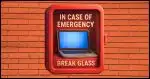 a laptop computer inside a wall-mount fire extinguisher container behind glass with the words "in case of emergency break glass" stenciled over the glass