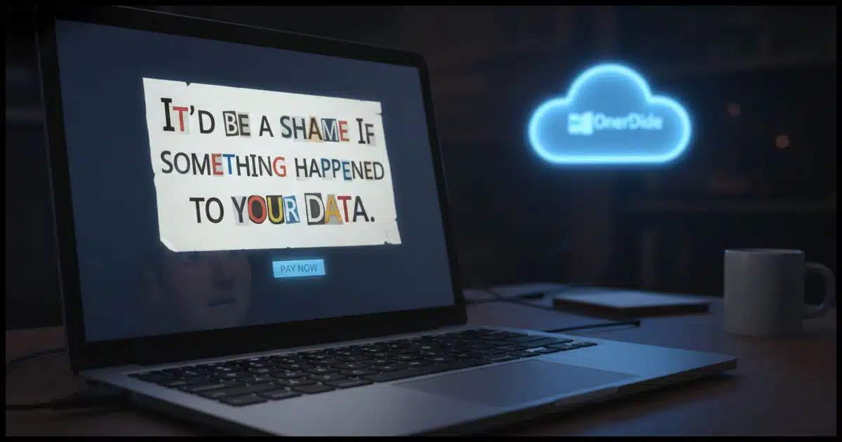 A high-contrast close-up of a modern laptop screen in a dark room. The screen displays a stylized, "ransom note" style popup with mismatched letters cut from digital fonts. The text reads: "IT&rsquo;D BE A SHAME IF SOMETHING HAPPENED TO YOUR DATA." In the background, out of focus, a blue OneDrive cloud icon glows ominously.